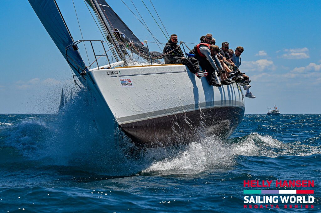 Sailboat rides up a wave on Lake Michigan