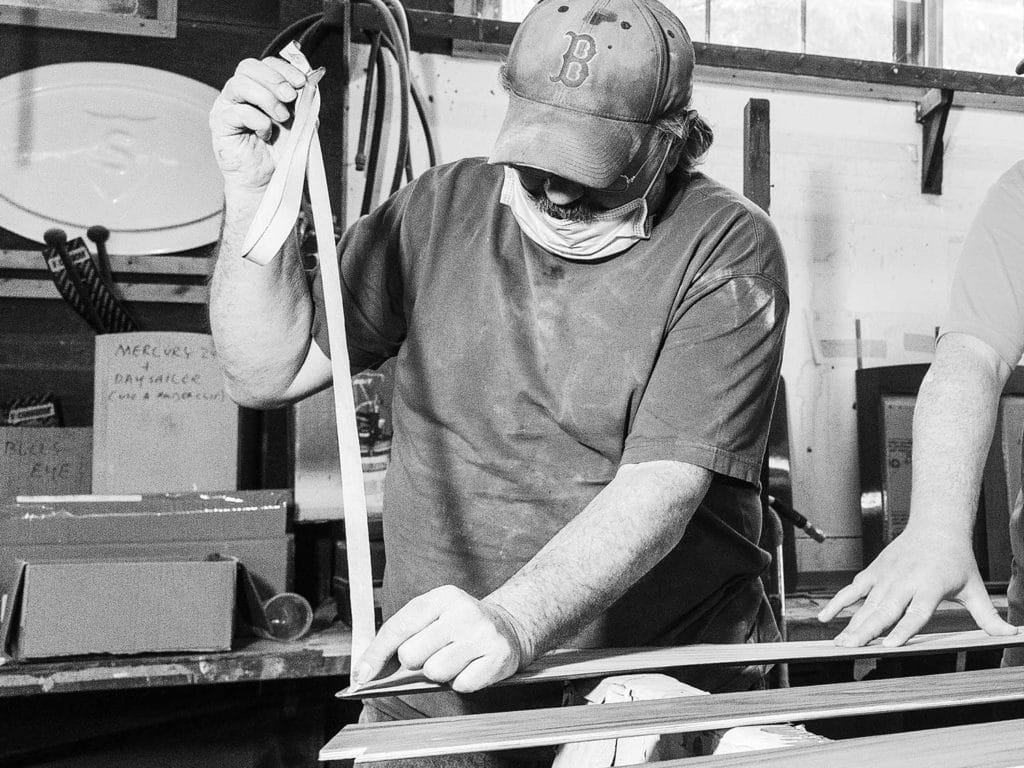 A man pulls tape in a workshop.