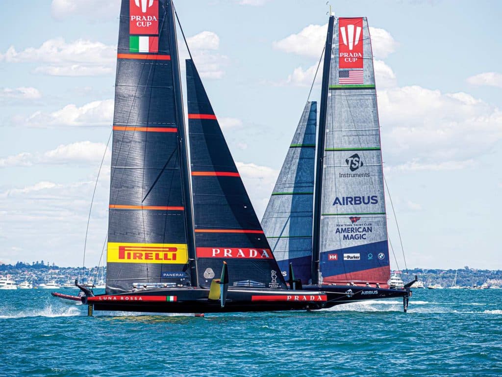 Two sailboats crossing paths in the water.